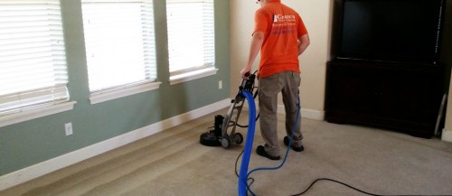 worker with machine cleaning carpet