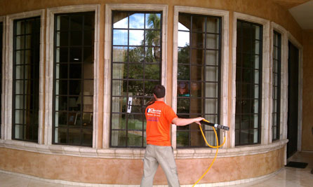 A window cleaning technician cleaning large windows using ultra pure water